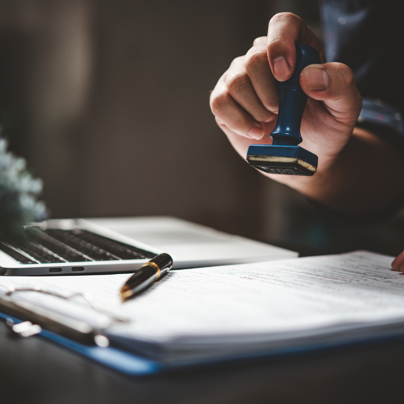 stock image, person stamping a document, used to show an imaginary vision of Canadian Work Permit being approved.